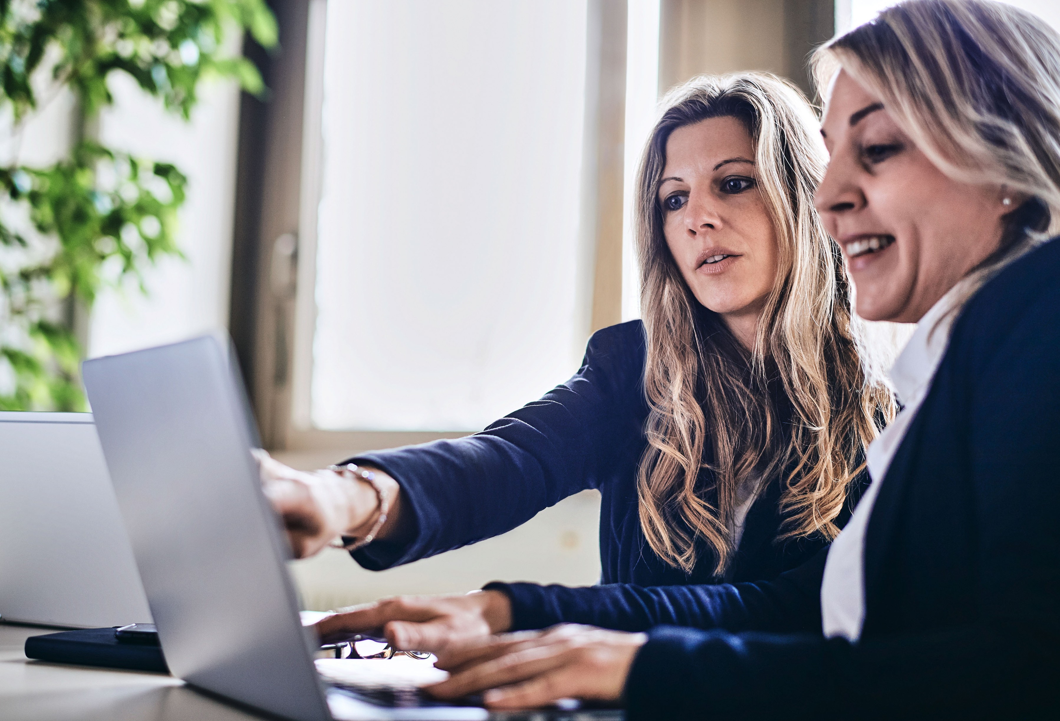 Zwei Frauen sitzen gemeinsam vor dem Computer