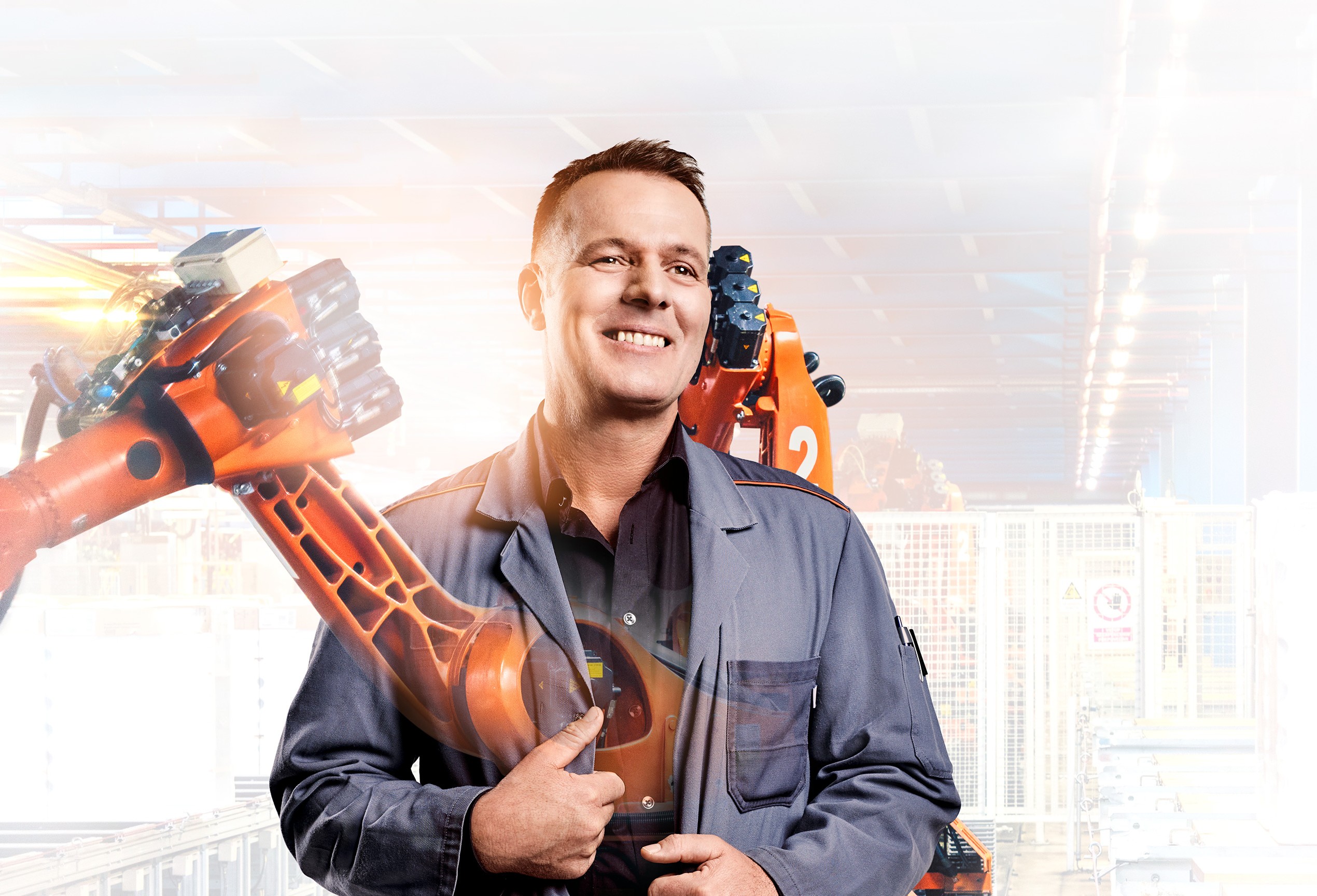 Schichtmeister Uwe mit Roboterarm im Hintergrund