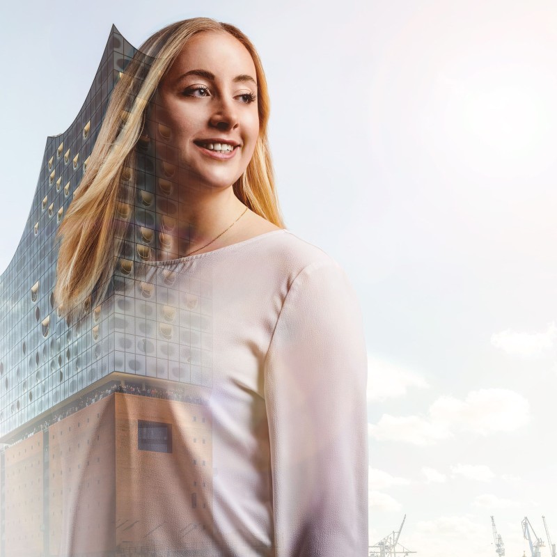 Studentin Franziska mit Blick auf den Hambuerg Hafen und der Elbphilharmonie im Hintergrund