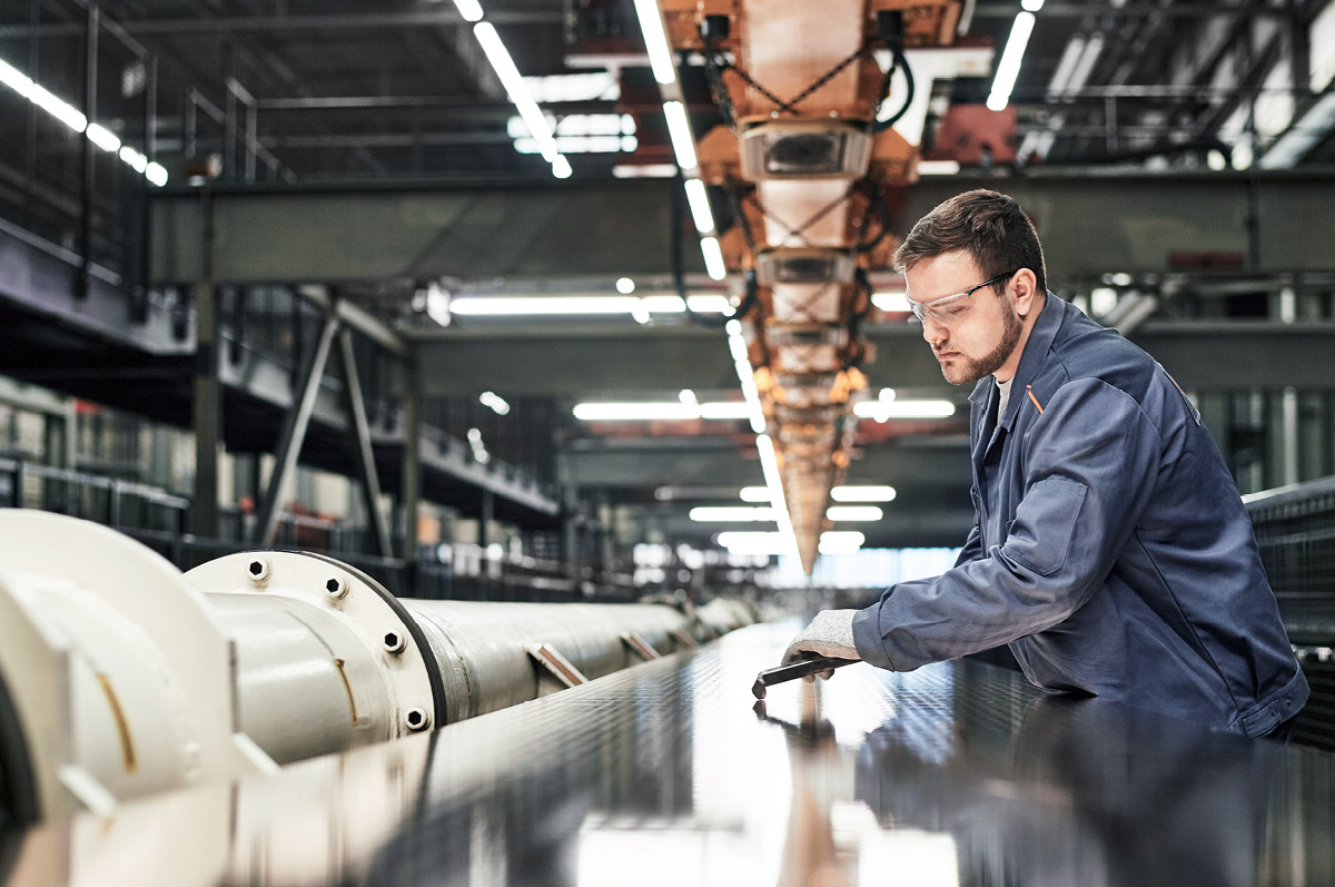 Mitarbeiter Fertigung prüft Material auf Qualität