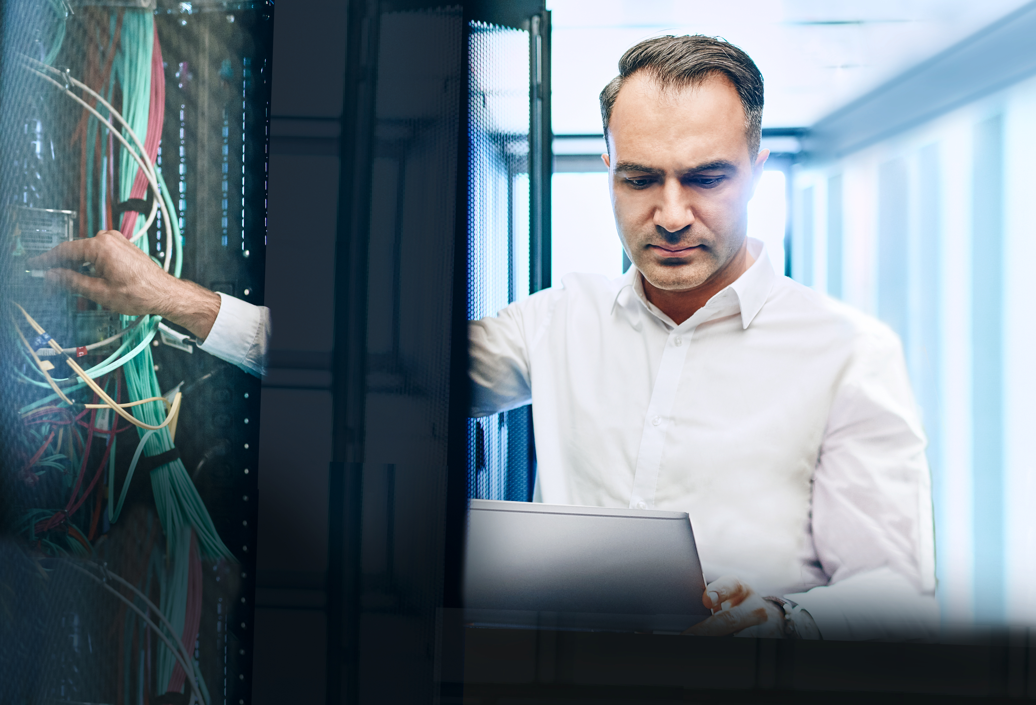 IT-Experte steht am Serverschrank und hält ein Tablet in der Hand