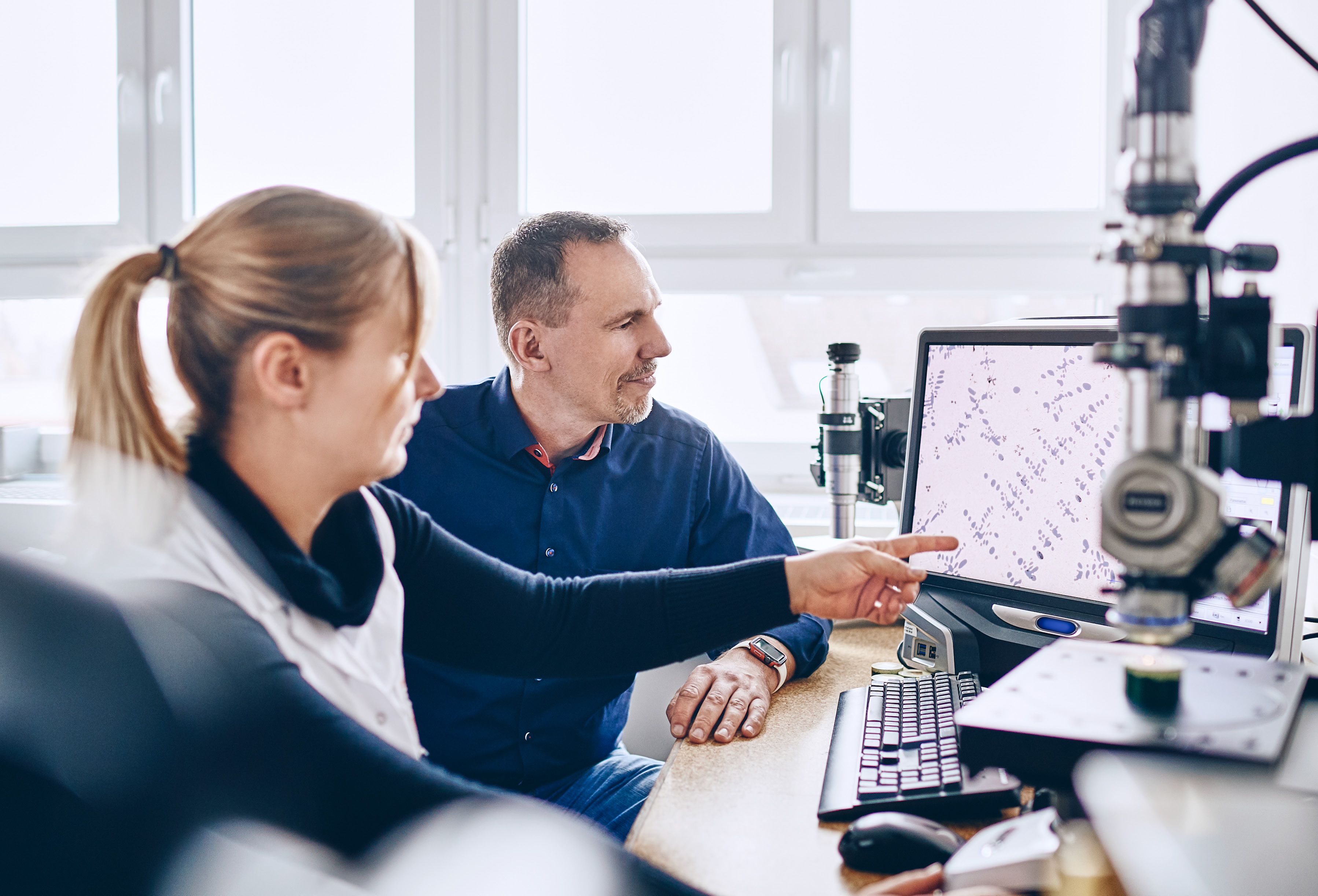 Zwei Materialwissenschaftler sitzten vor einen Elektronenmikroskop