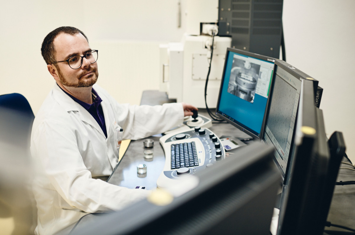 Materialwissenschaftler in Laborkittel sitzt am Computer