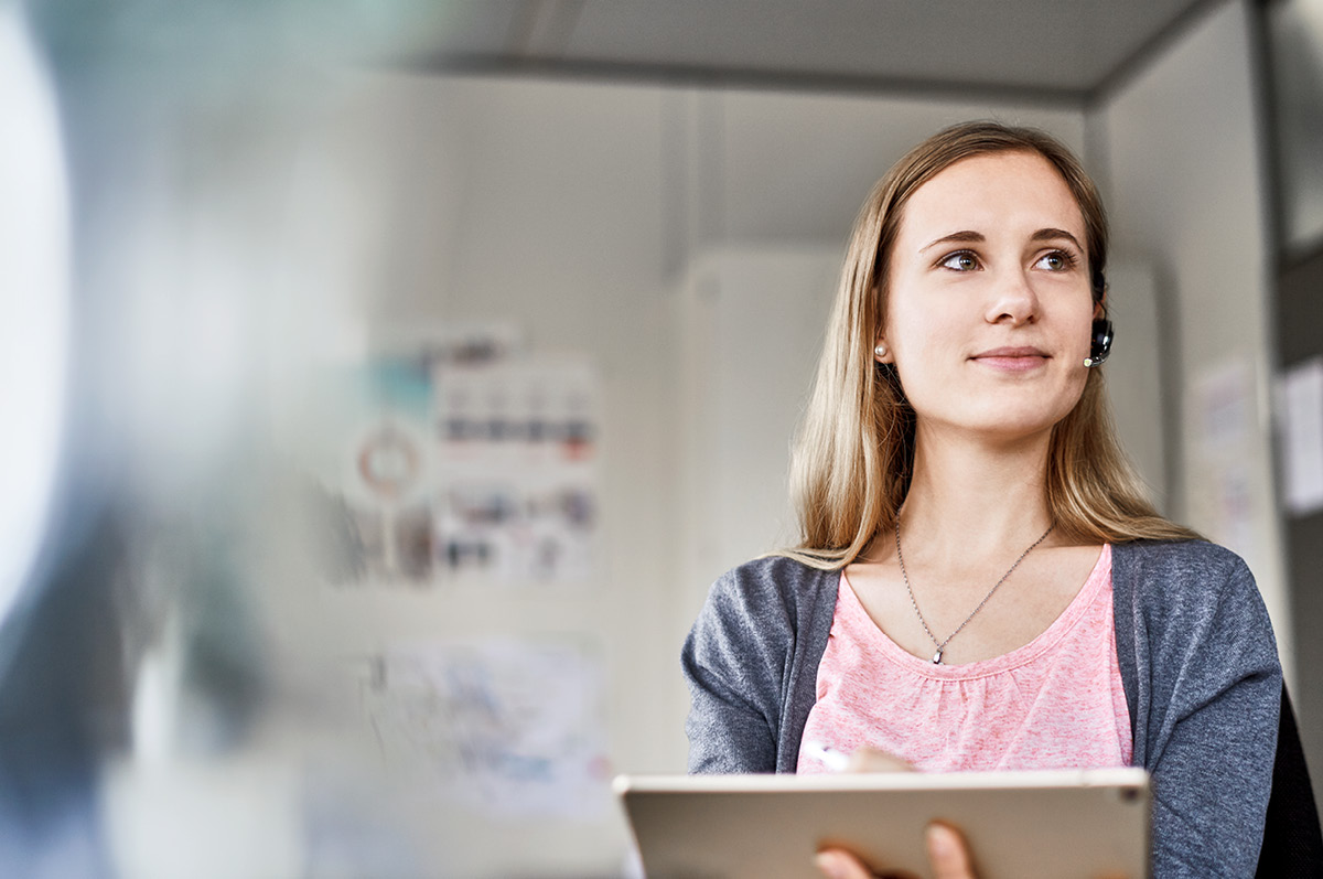 Junge Mitarbeiterin mit Headset